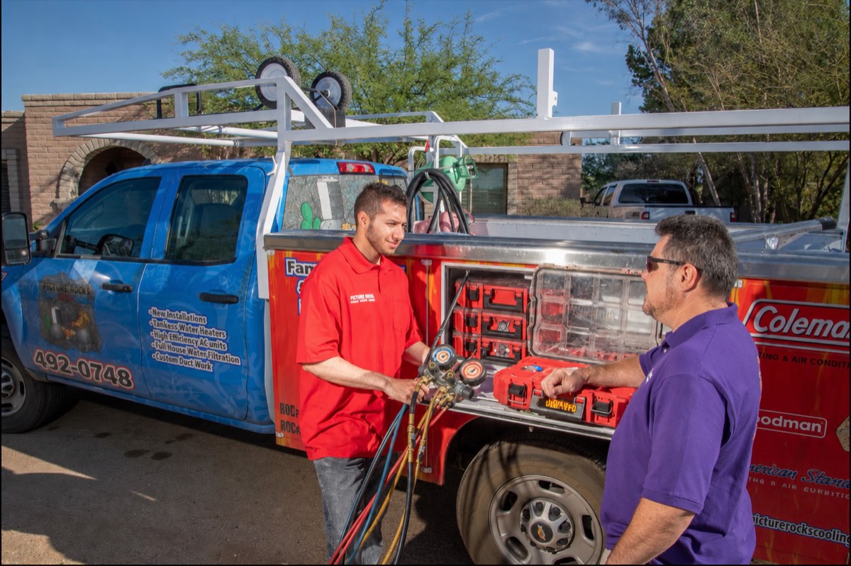 Picture Rocks HVAC technicians with a service truck and diagnostic gauges