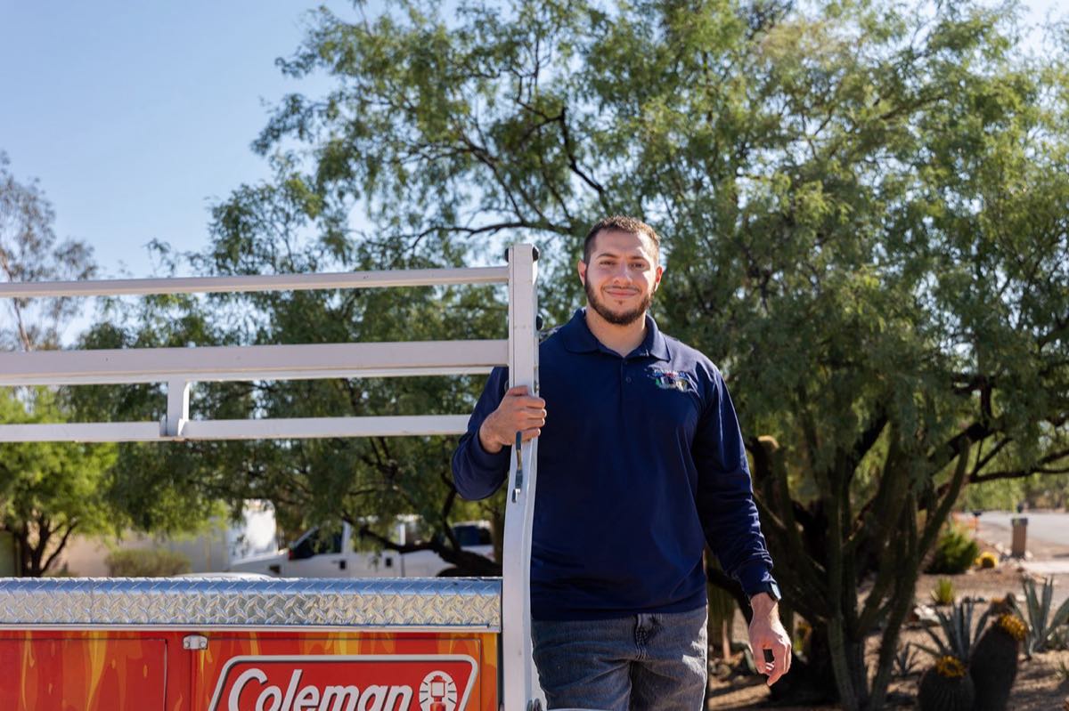 Picture Rocks HVAC technician standing beside a branded service truck